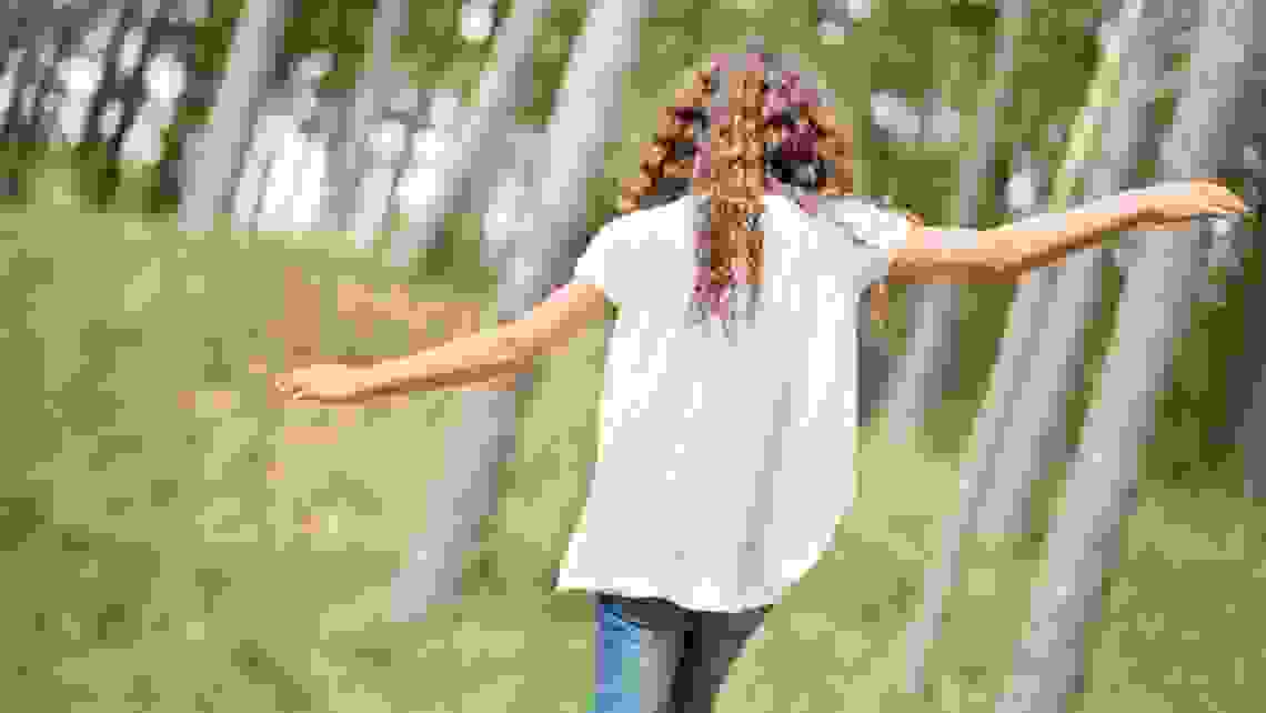 en flicka går i skogen