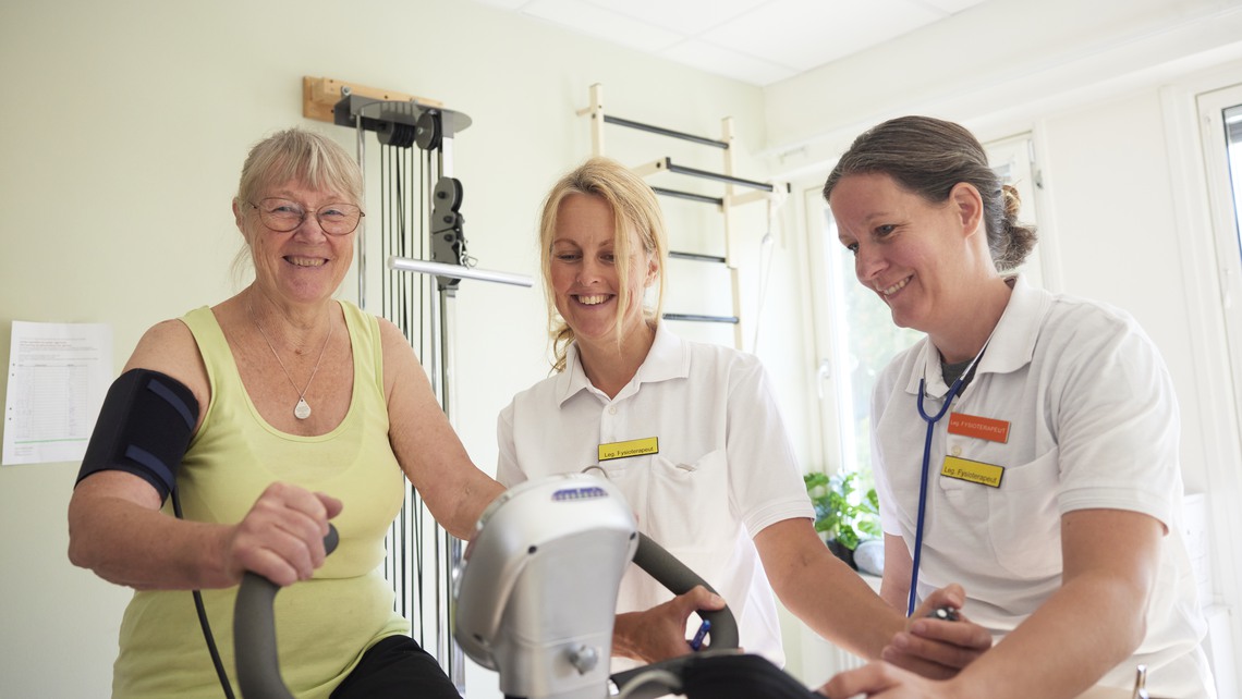 Patient på rehabilitering med fysioterapeut på motionscykel