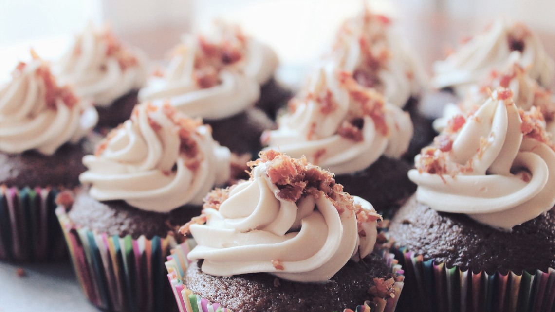 Ett gäng cupcakes av choklad med vit topping.