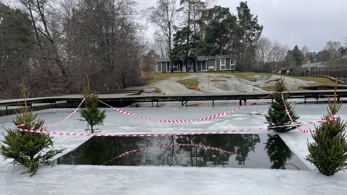 Isvak på Ösbysjön markerad med granar.